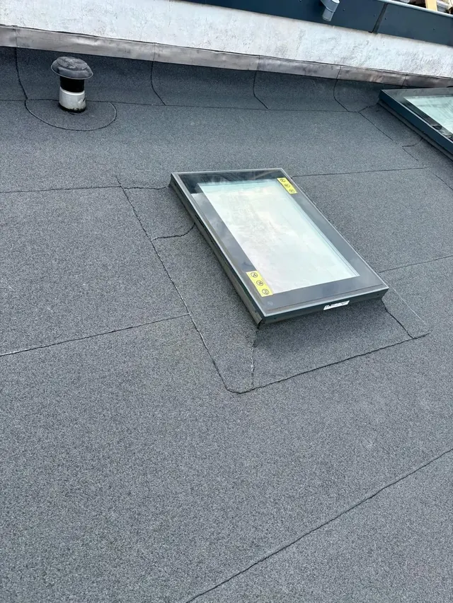 Aansluiting van een lichtkoepel — De dakbedekking loopt aan op de verhoogde opstand rond de lichtkoepel.